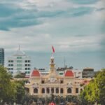 A vibrant cityscape featuring the iconic People's Committee Building in Ho Chi Minh City, Vietnam.
