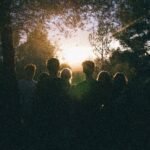 A group of friends enjoying a scenic sunset in a forest, capturing a moment of togetherness.